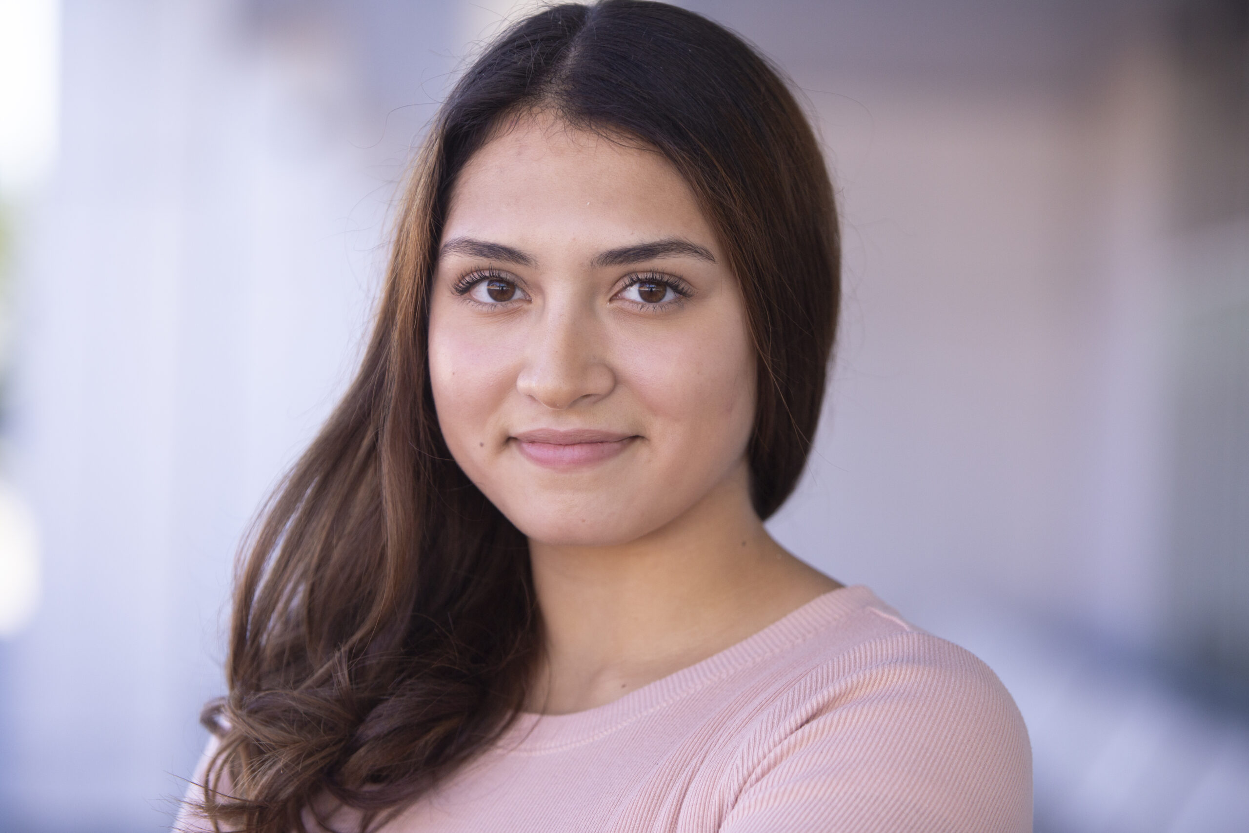 Female Calgary actor on location headshot wearing pink shirt.